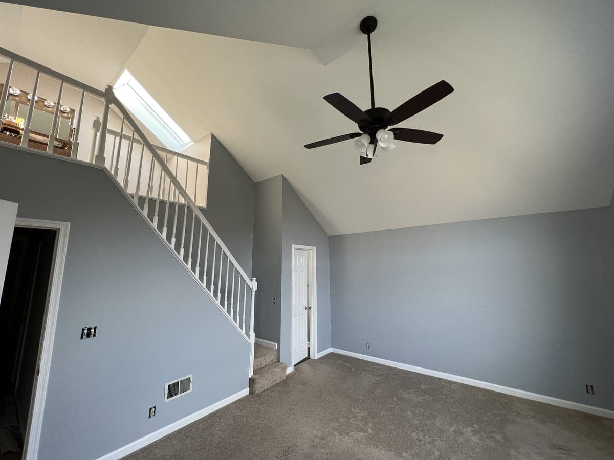 Same blue-gray room from the other side, stair and closet door, vaulted ceiling