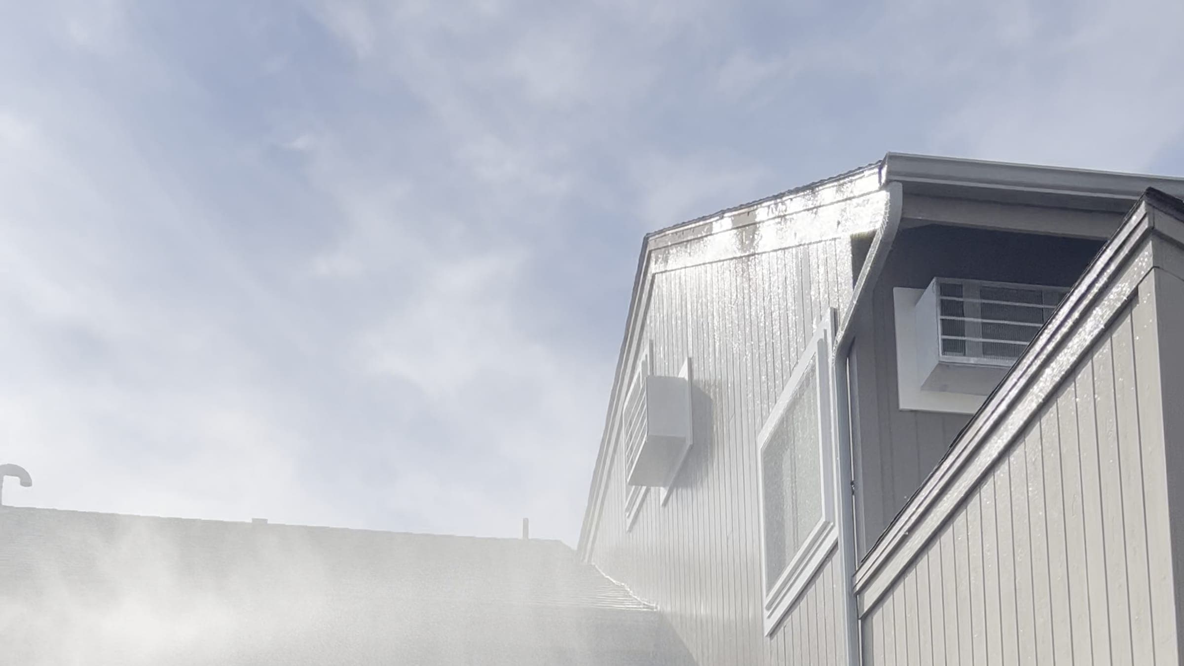 Wash water sheeting off the upper siding of an apartment elevation